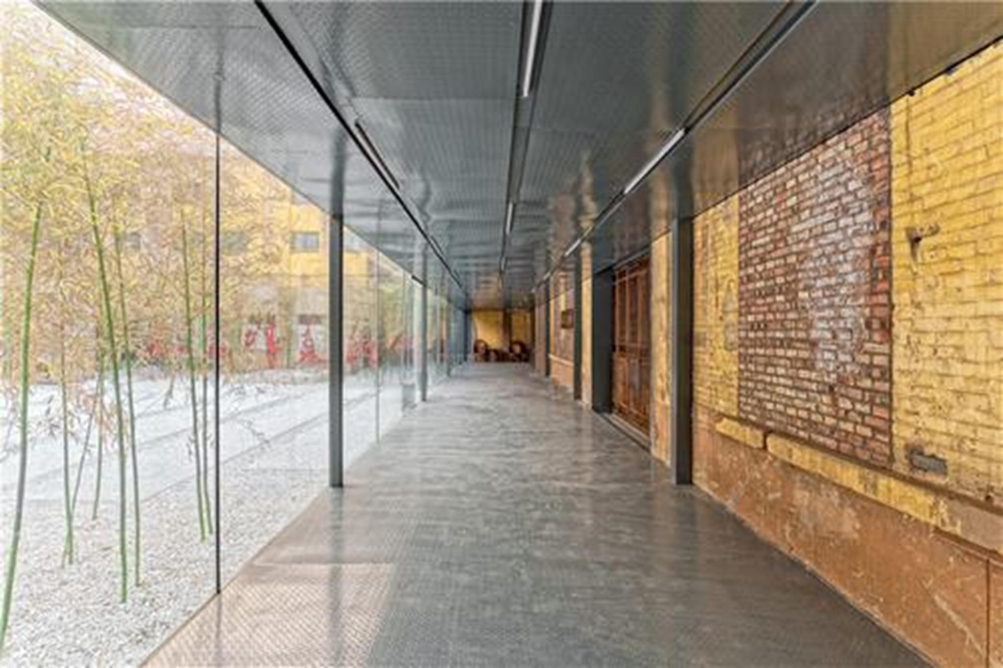 Một hành lang mờ kết nối nội thất và ngoại thất và làm nổi bật sự tương phản giữa những đặc điểm cũ và mới