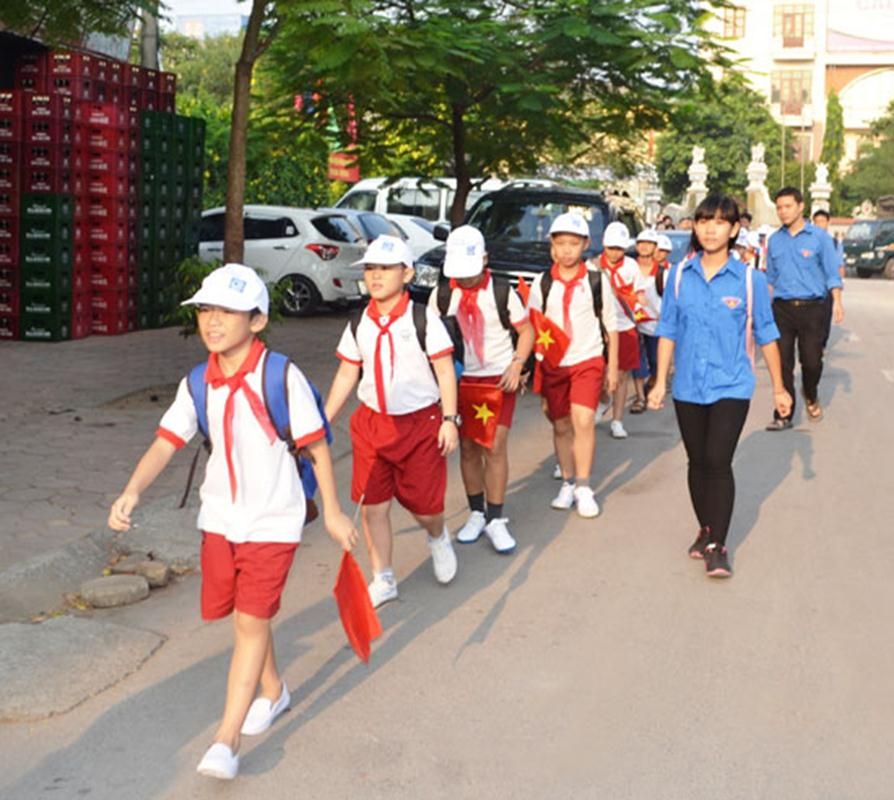Học sinh trường Tiểu học Hạ Đình đến trường dưới sự dẫn dắt của tình nguyện viên.