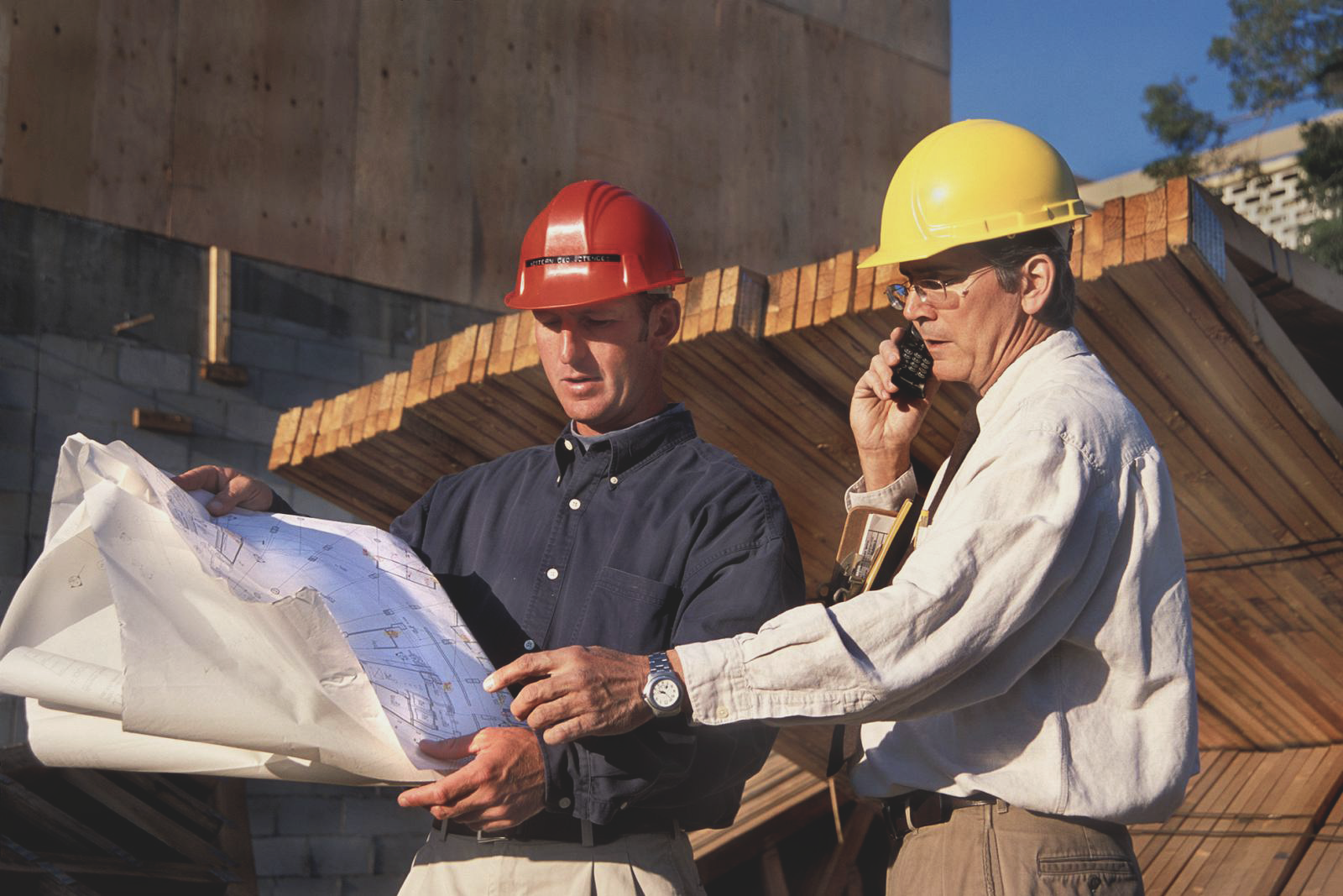 Architect and contractor discuss plan at construction
